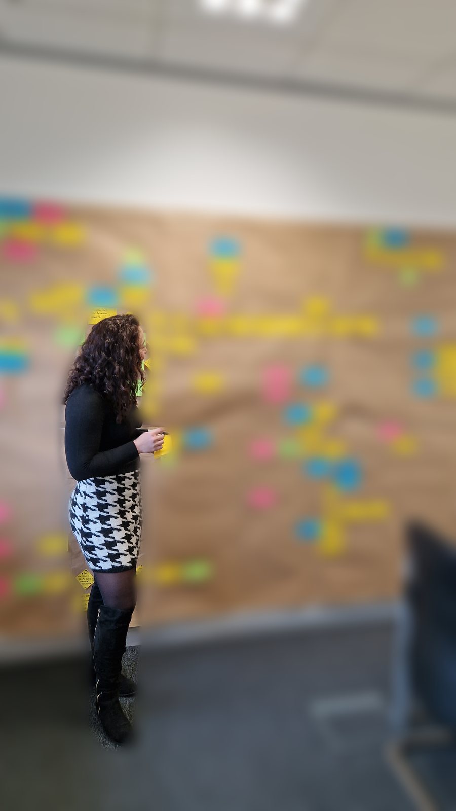 Rose Attridge working in front of a large brown-paper process map